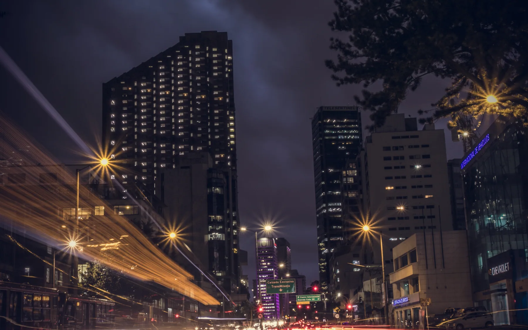 City street lights streaking through downtown after dark